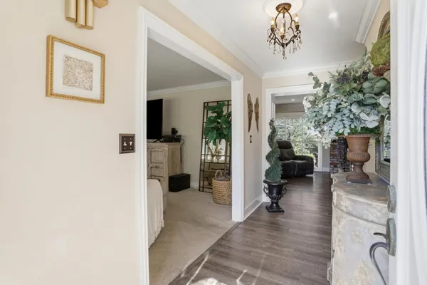 a hallway with a dining table a chandelier and a couch