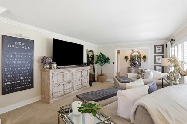 a living room with furniture a flat screen tv and a floor to ceiling window