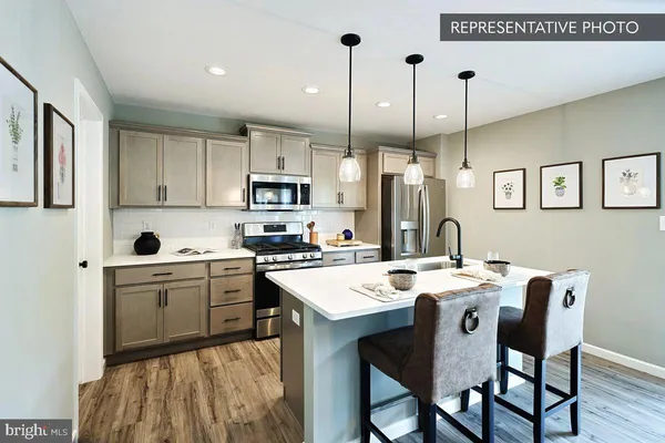 a kitchen with stainless steel appliances kitchen island granite countertop a stove a sink a dining table and chairs