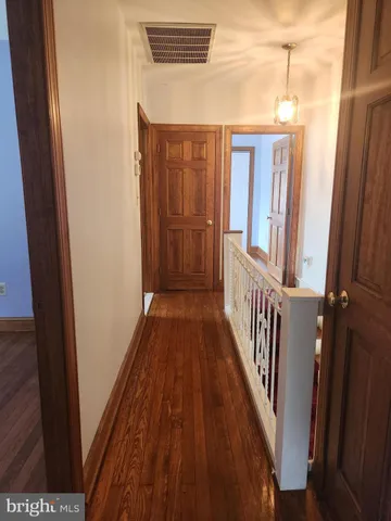 an empty room with wooden floor closet and windows