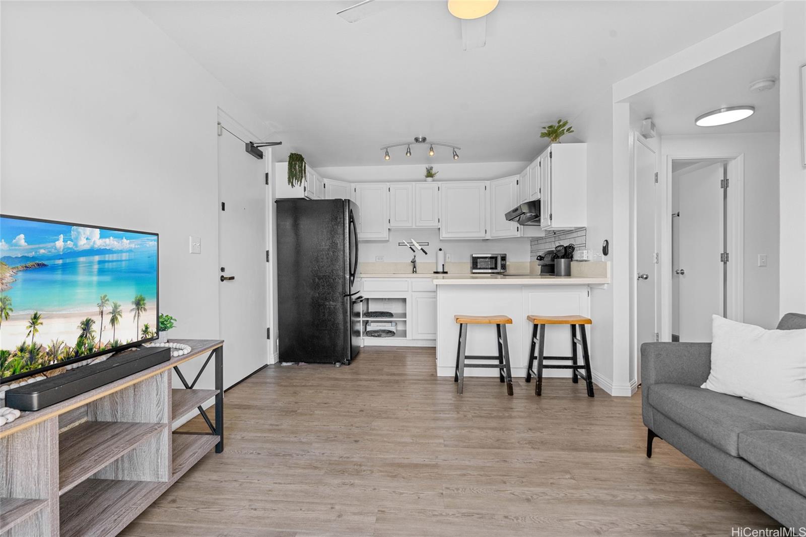 1432 Ke’eaumoku Street, Unit 201 Honolulu, HI 96822 - Photo 1 of 1 a living room with stainless steel appliances kitchen island furniture and a table