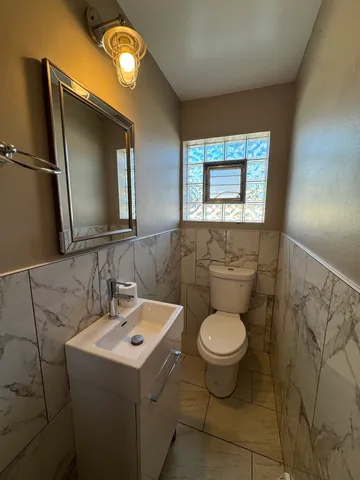 a bathroom with a toilet sink and mirror