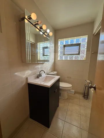 a bathroom with a sink mirror vanity and toilet