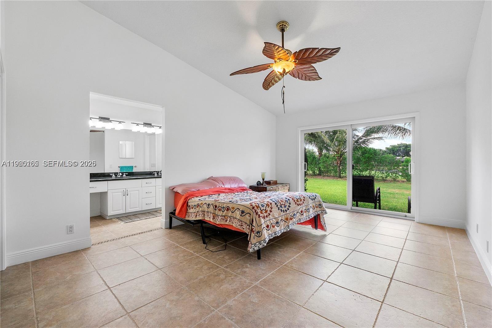 5667 North Cameo Drive Boca Raton, FL 33433 - Photo 25 of 32 a living room with a bed and a chandelier