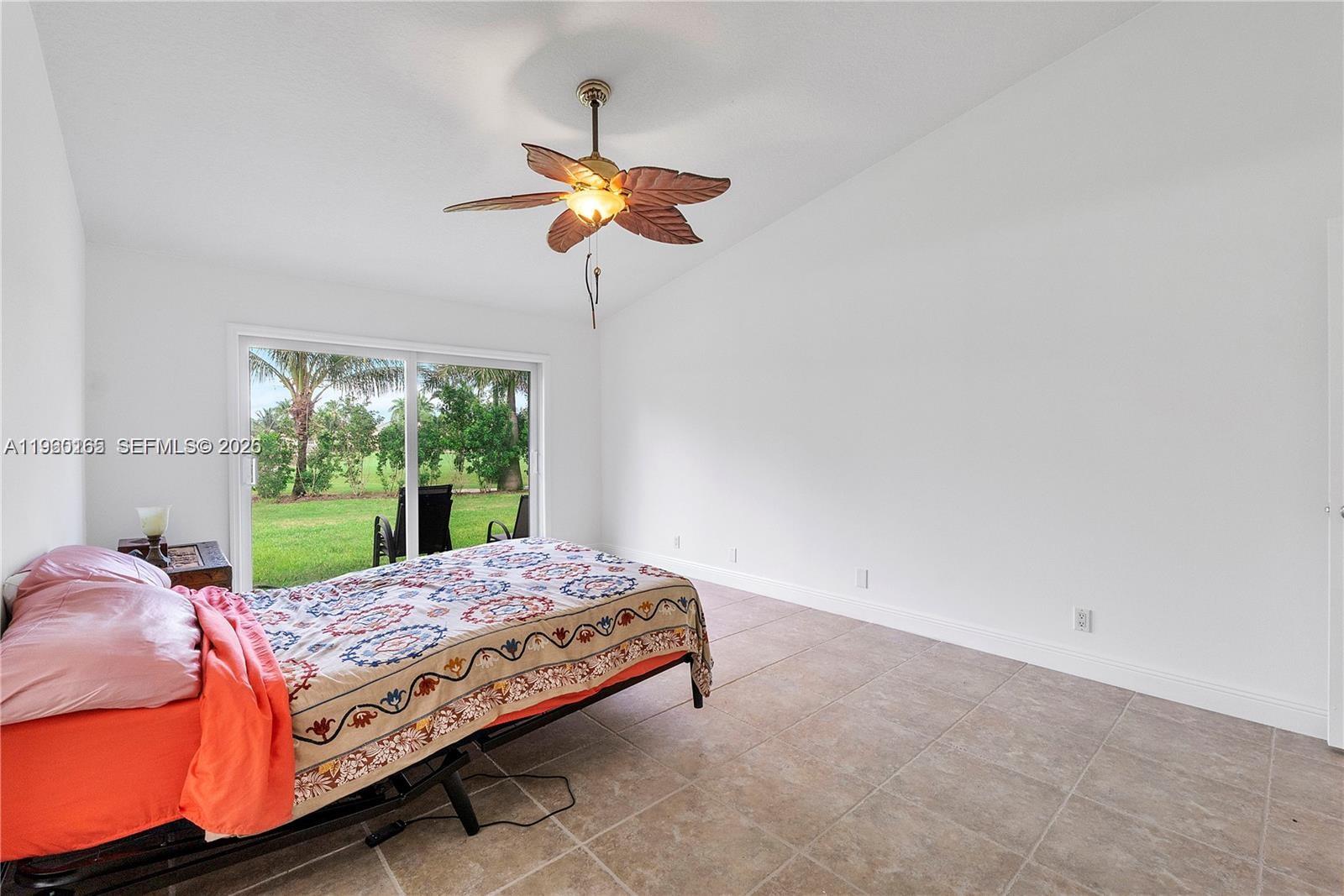 5667 North Cameo Drive Boca Raton, FL 33433 - Photo 26 of 32 a bedroom with a bed and a chandelier