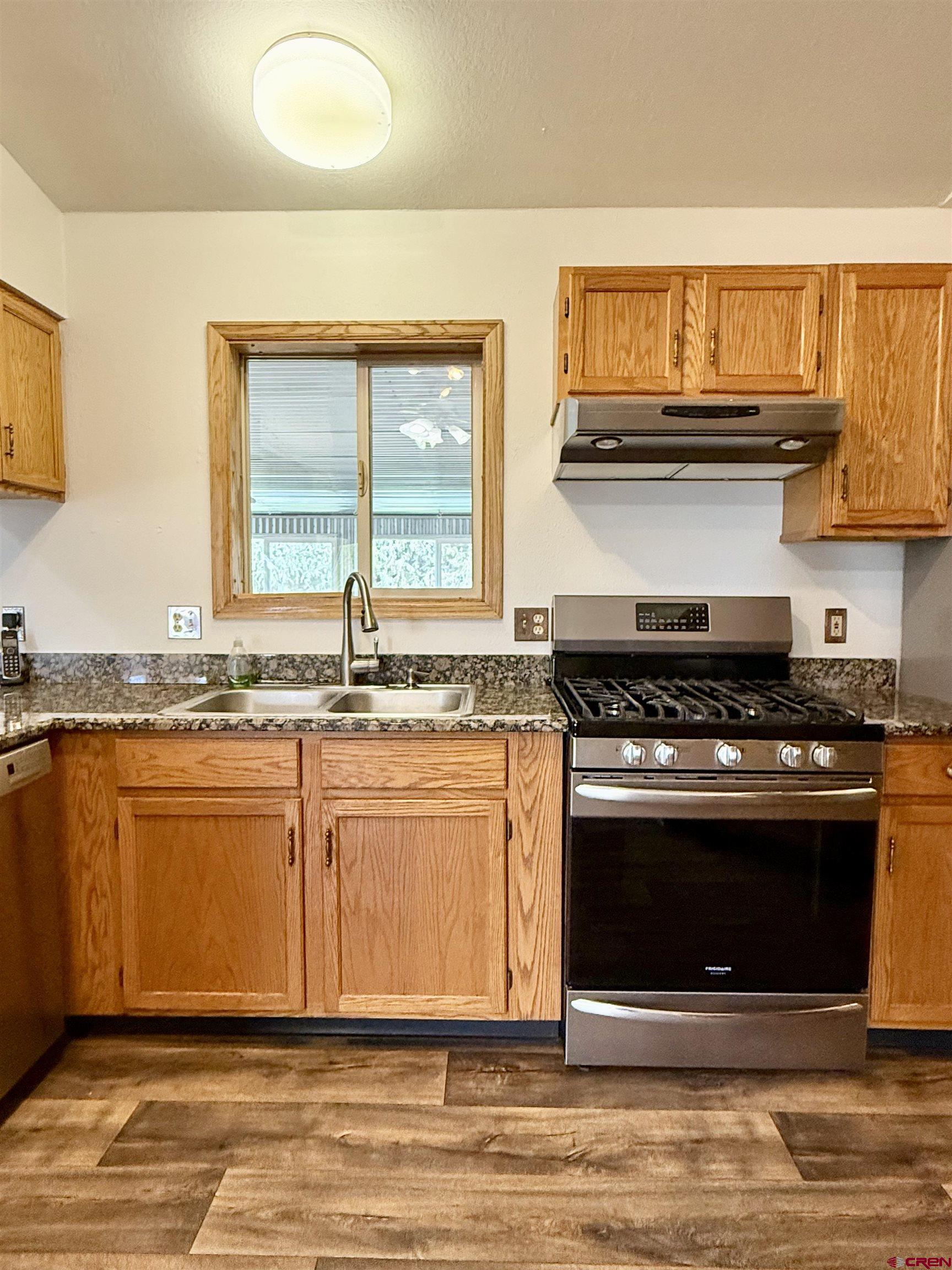 14894 Deer Run Road Delta, CO 81416 - Photo 11 of 40 a kitchen with stainless steel appliances granite countertop a stove a sink and a microwave
