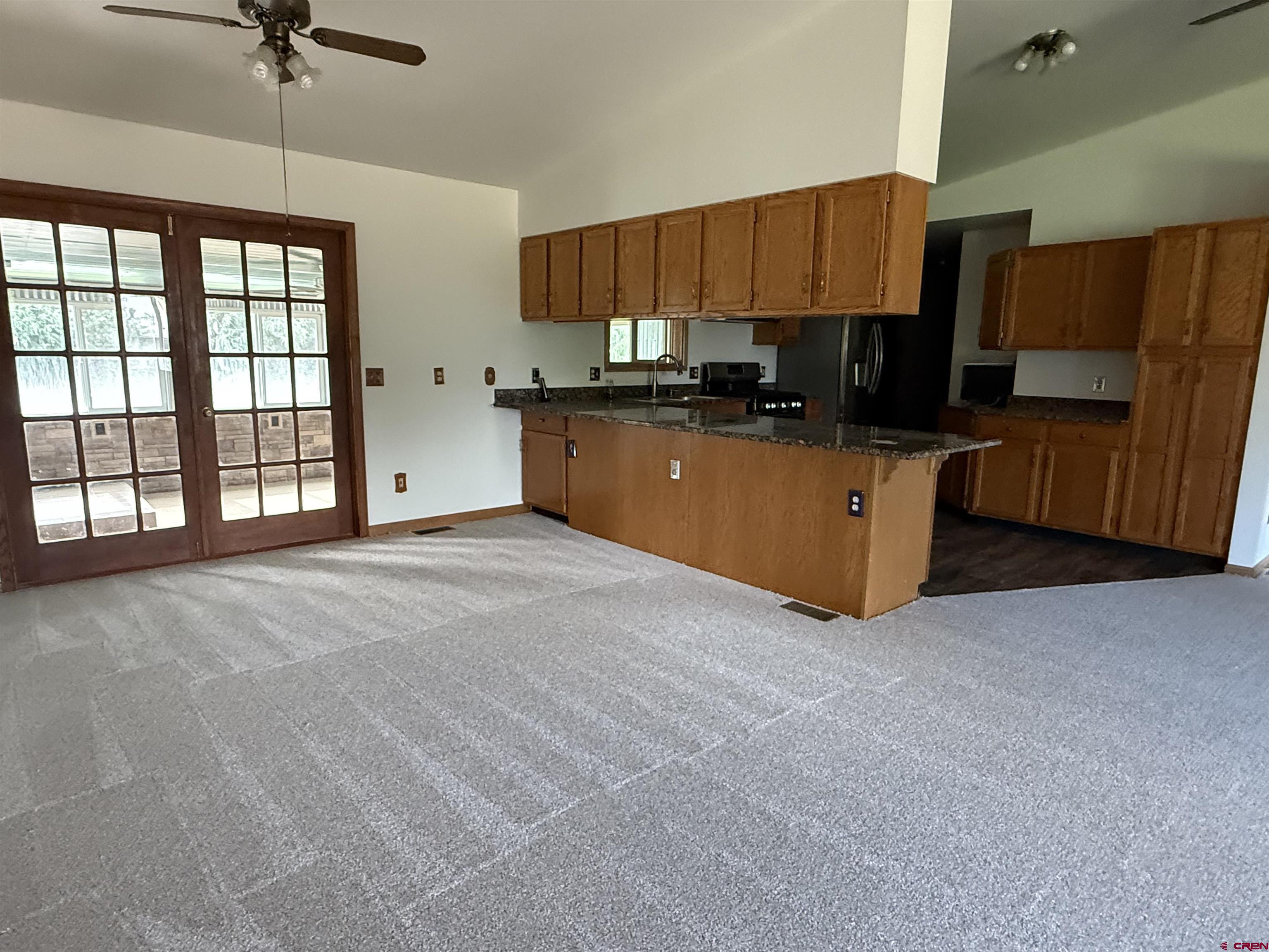 14894 Deer Run Road Delta, CO 81416 - Photo 9 of 40 a large kitchen with stainless steel appliances granite countertop a stove a sink and a refrigerator
