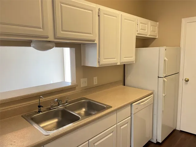 a kitchen with stainless steel appliances white cabinets and a sink