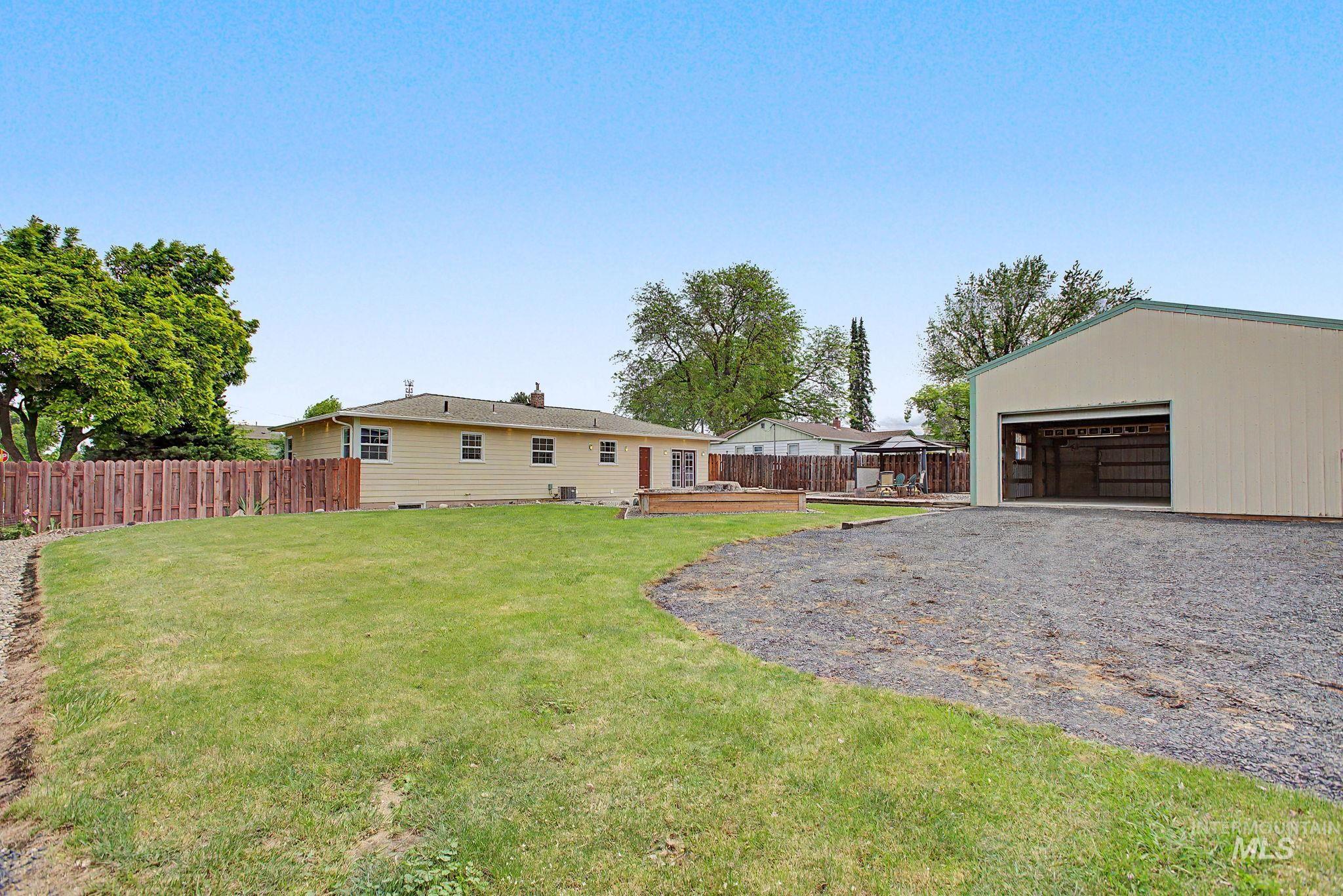 3314 6th Street Lewiston, ID 83501 - Photo 44 of 50 Expansive backyard featuring a manicured lawn, gravel area, and a large detached outbuilding with an open bay