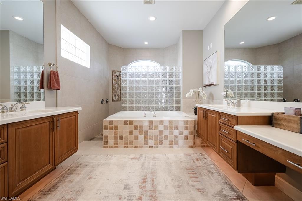1942 Kingfish Road Naples, FL 34102 - Photo 25 of 43 a spacious bathroom with a double vanity sink a large mirror and a bathtub