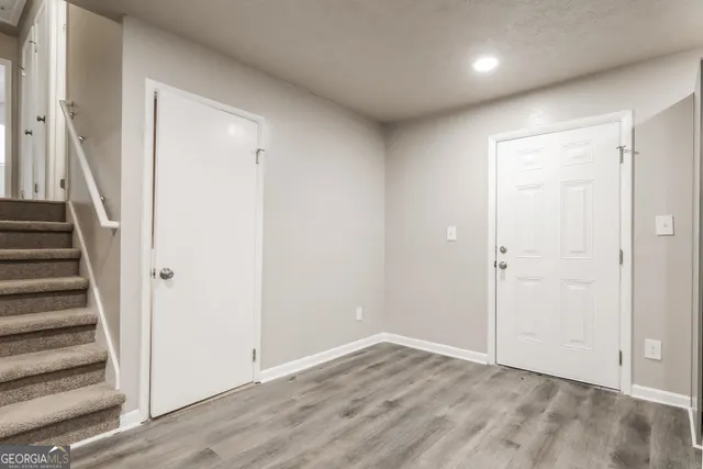 a view of an empty room with wooden floor and entryway