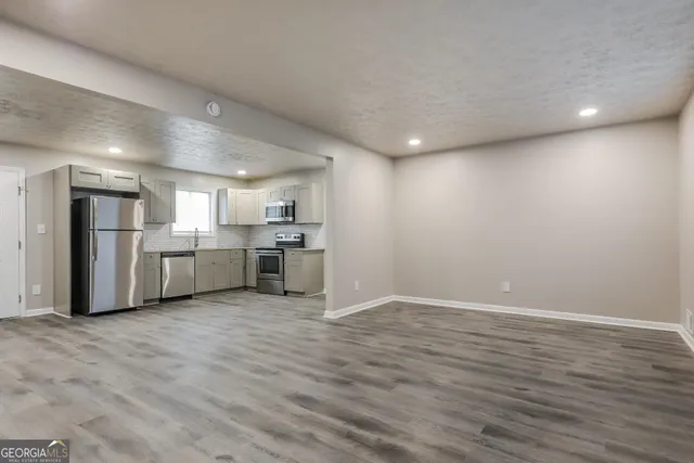 a view of a kitchen with a sink and white cabinets