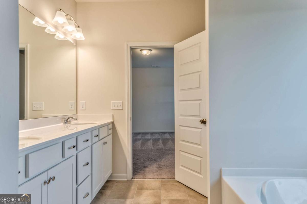 8 Majestic Oaks Way Northeast Rome, GA 30165 - Photo 23 of 25 a bathroom with a double vanity sink a mirror and a bathtub