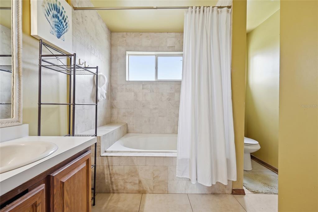 3027 Queens Gate Road Orlando, FL 32818 - Photo 30 of 34 a bathroom with a granite countertop sink toilet and shower
