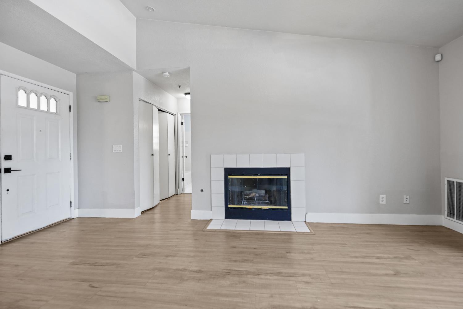 8020 Walerga Road, Unit 1090 Antelope, CA 95843 - Photo 6 of 24 a view of an empty room with wooden floor fireplace and a window