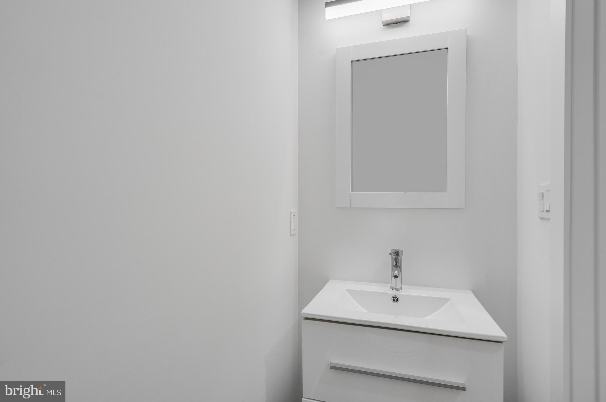 4626 Brooks Street Northeast Washington, DC 20019 - Photo 41 of 65 a bathroom with a sink a mirror and vanity