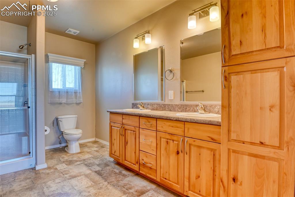 22500 Enoch Road Calhan, CO 80808 - Photo 20 of 39 a bathroom with a toilet a sink and mirror