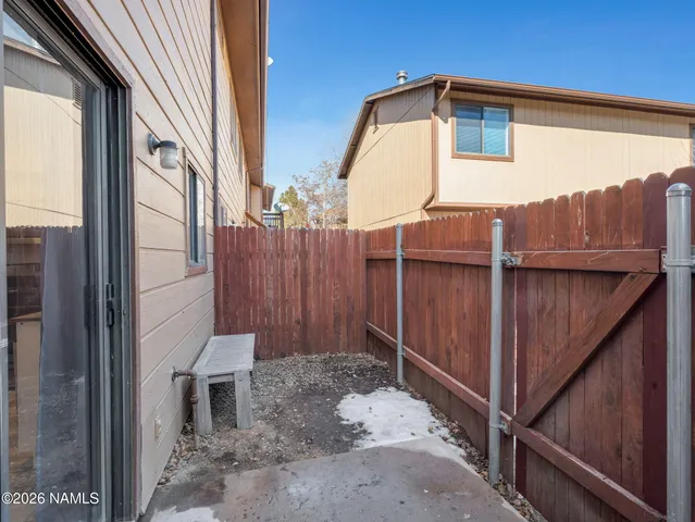 a view of a small house with wooden fence