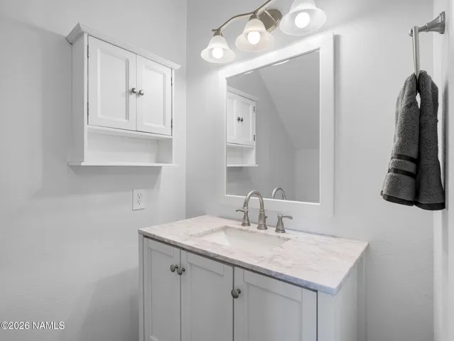 a bathroom with a sink vanity and a mirror