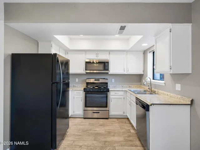 a kitchen with stainless steel appliances granite countertop a refrigerator stove and sink