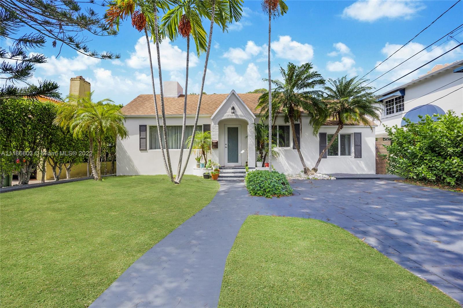 256 Southwest 30th Road Miami, FL 33129 - Photo 1 of 17 a front view of a house with a garden and palm trees