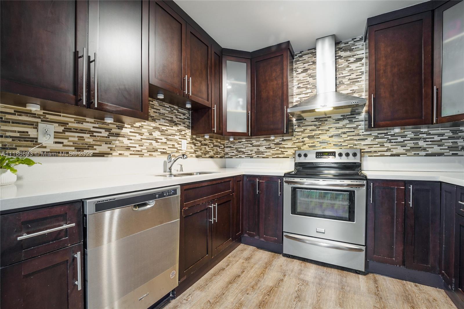 256 Southwest 30th Road Miami, FL 33129 - Photo 3 of 17 a kitchen with stainless steel appliances granite countertop a sink stove and microwave