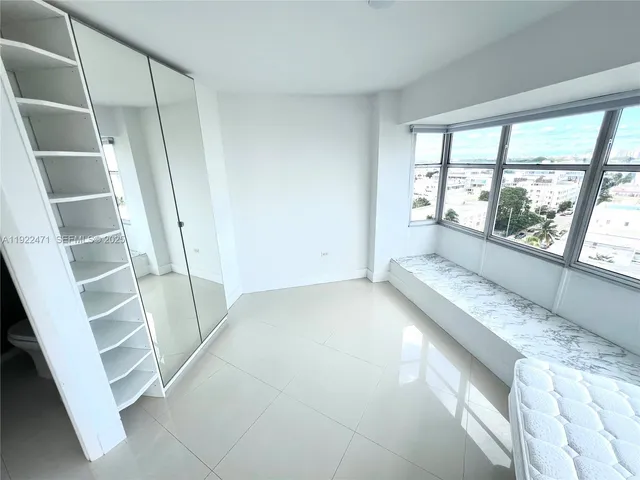 a spacious bedroom with a large bed and a large window