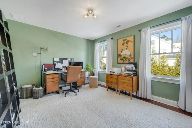 a view of a workspace with furniture and a window