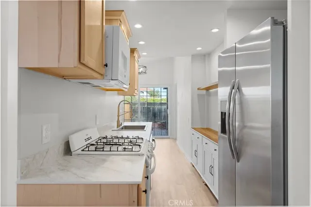 a kitchen with granite countertop stainless steel appliances and a refrigerator