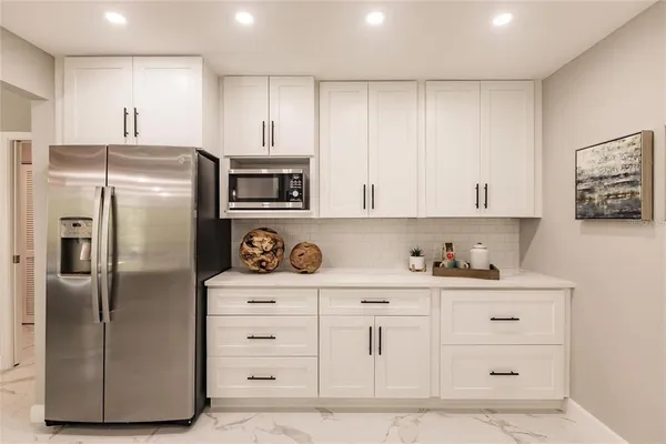 a kitchen with white cabinets and stainless steel appliances