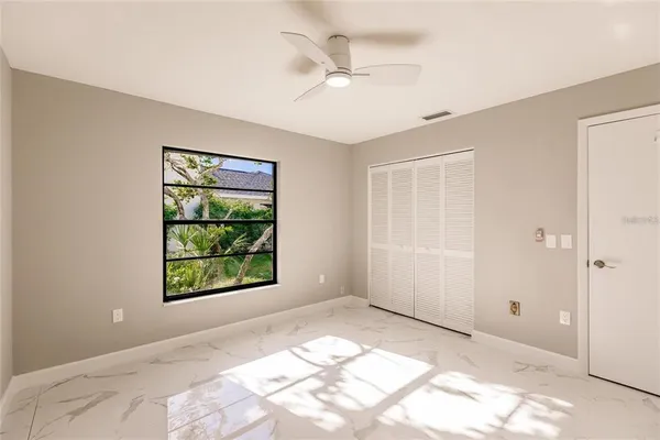 a view of a bedroom with a window and a ceiling fan