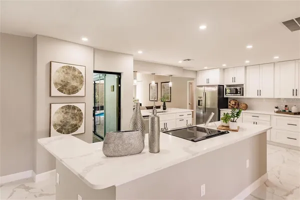 a kitchen with stainless steel appliances granite countertop a refrigerator and a stove top oven