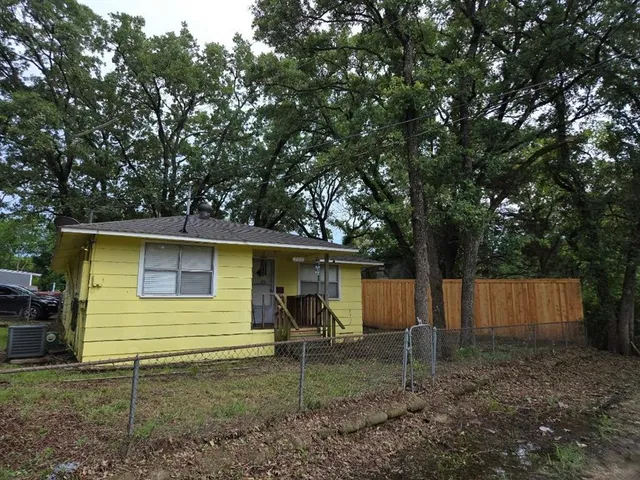 a view of a house with backyard and a tree
