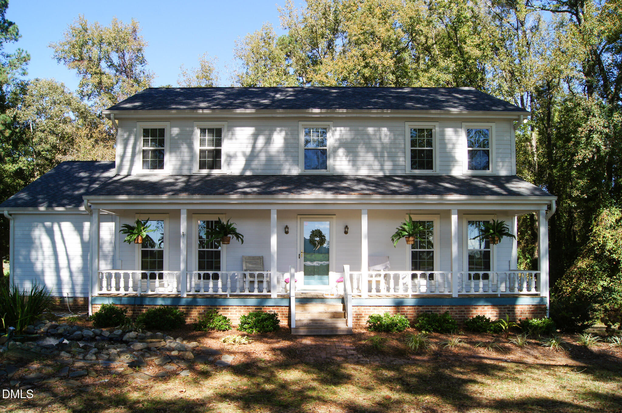 a view of a white house with large windows and a small yard
