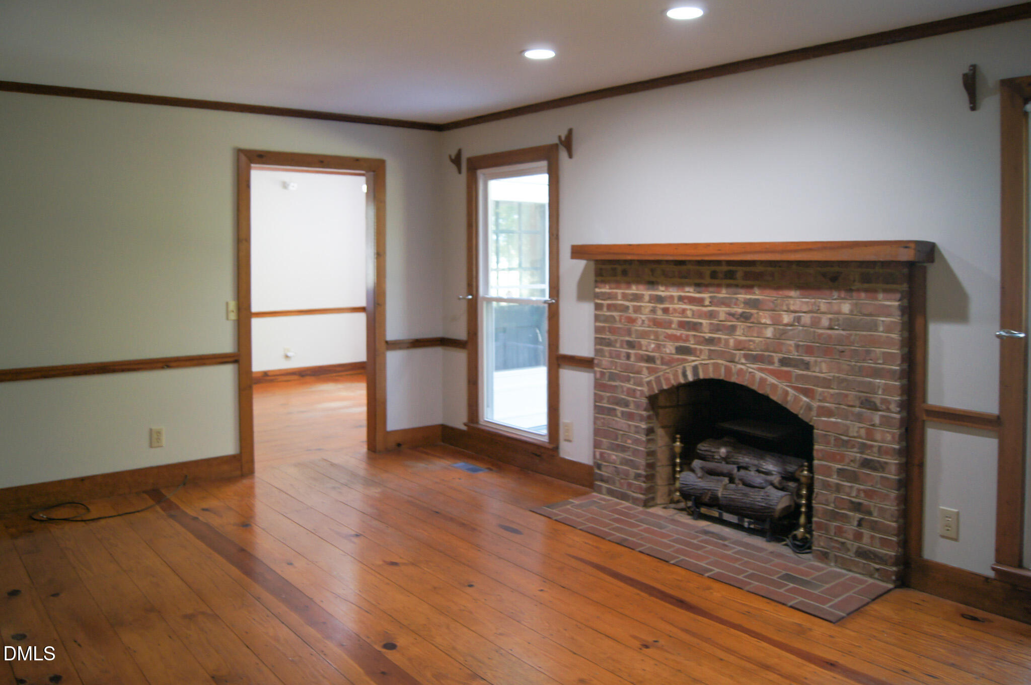 8720 Mt Pleasant Church Road Willow Spring, NC 27592 - Photo 19 of 77 an empty room with wooden floor and fireplace
