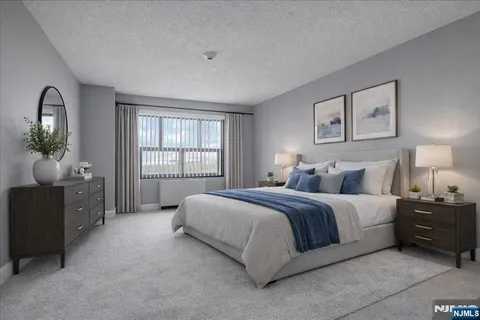 a spacious bedroom with a bed and a dresser next to a window
