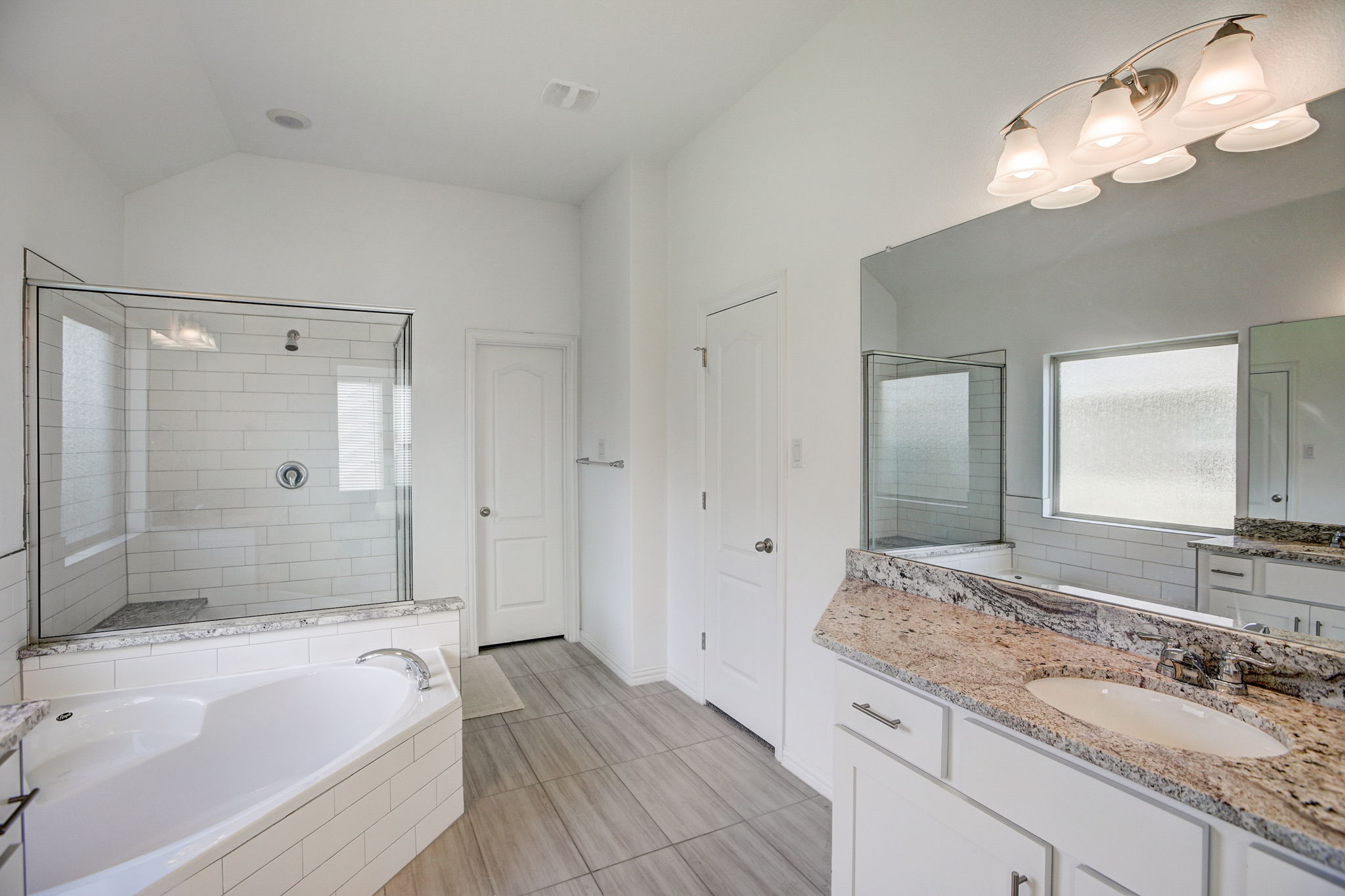 308 Monteforte Road Hutto, TX 78634 - Photo 15 of 32 a bathroom with a granite countertop bathtub a sink and a mirror