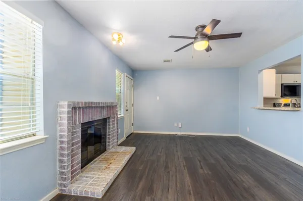a view of empty room with wooden floor and fireplace