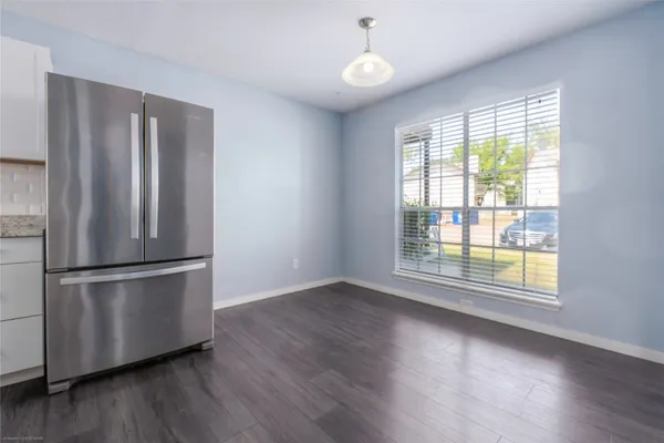 a view of a kitchen with wooden floor and stainless steel appliances
