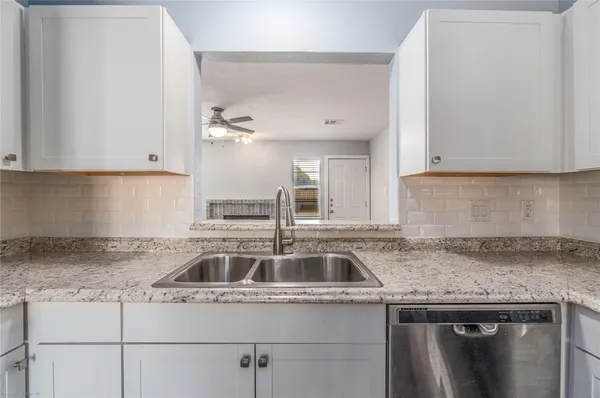 a kitchen with granite countertop a sink and a stove