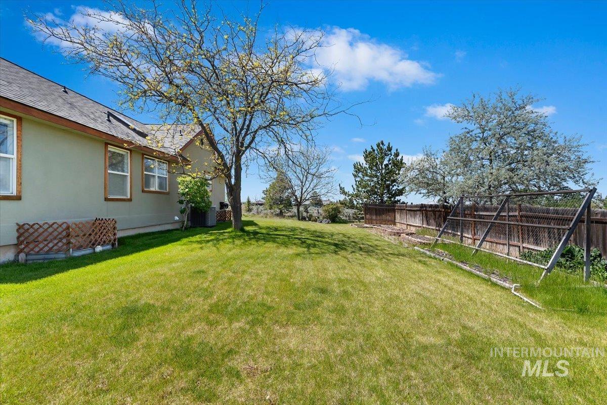 147 East Indian Crk Road Boise, ID 83716 - Photo 35 of 43 Expansive green lawn bordering a stucco exterior with multiple windows