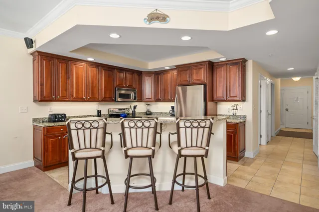 a kitchen with stainless steel appliances granite countertop a table chairs refrigerator a sink and dishwasher