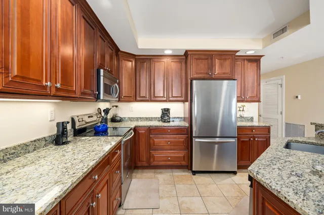 a kitchen with stainless steel appliances granite countertop a refrigerator and a sink