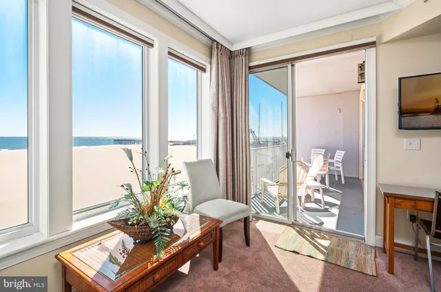 a living room with furniture a flat screen tv and a large window