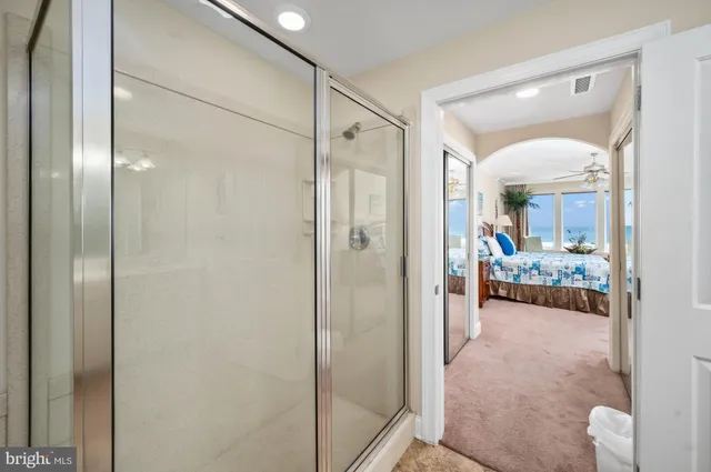 a bathroom with a glass shower door and a mirror