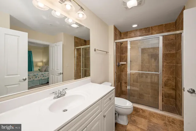 a bathroom with a sink vanity mirror and toilet