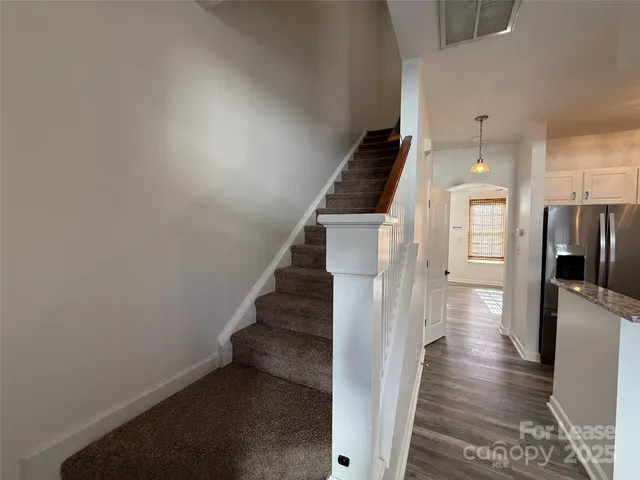 a view of a hallway with wooden floor and staircase