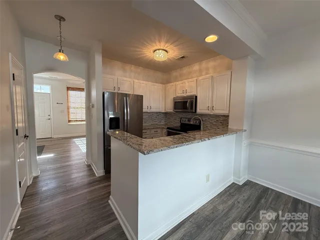 a kitchen with stainless steel appliances a refrigerator and microwave