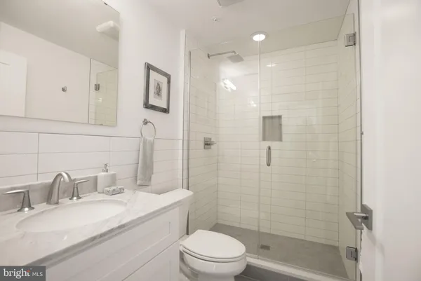 a bathroom with a granite countertop sink toilet and shower