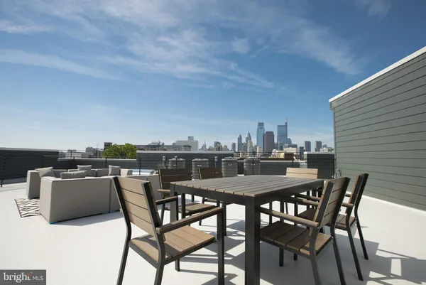 a view of a roof deck with table and chairs